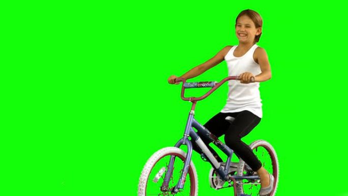 绿色屏幕上骑自行车的小女孩