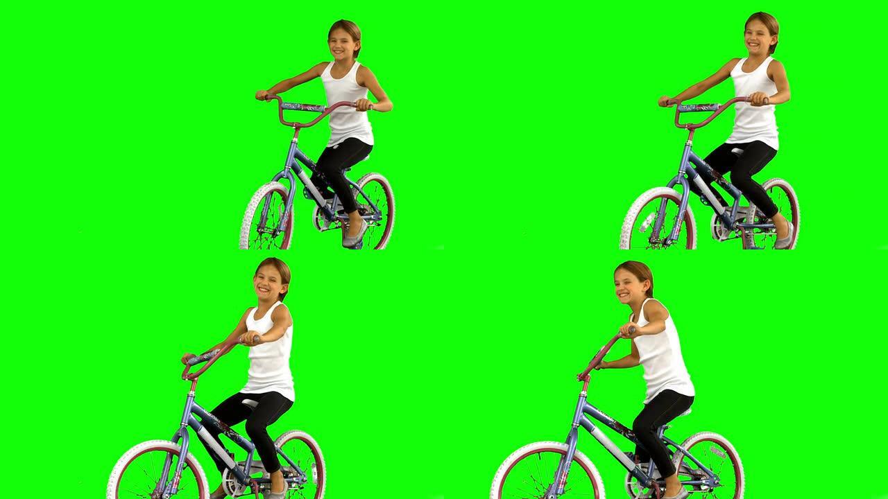 绿色屏幕上骑自行车的小女孩