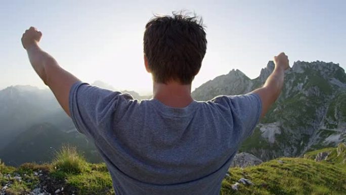 近距离镜头耀斑: 男子庆祝在阳光普照的下午到达陡峭的山顶。