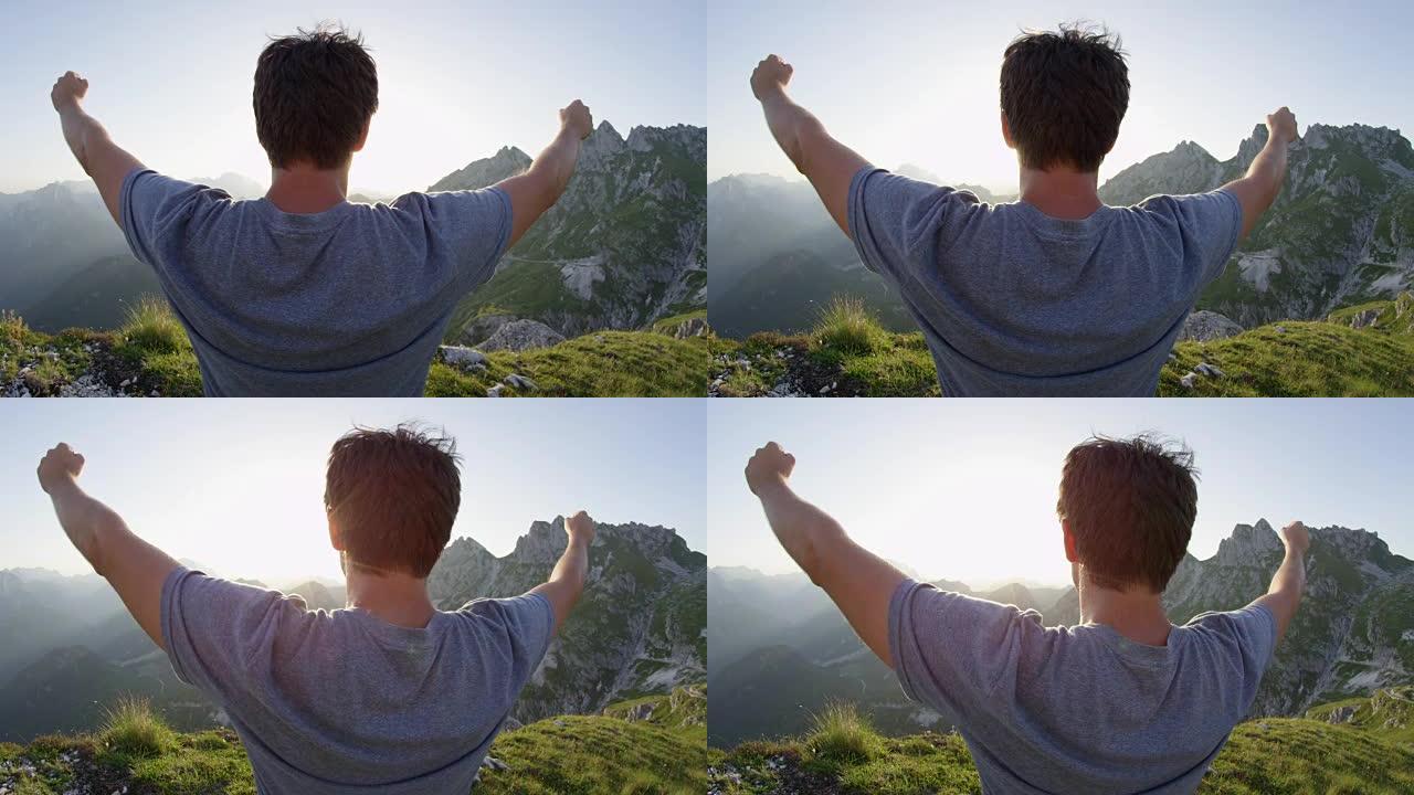 近距离镜头耀斑: 男子庆祝在阳光普照的下午到达陡峭的山顶。