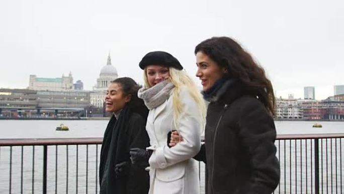 女性朋友在冬季访问伦敦时沿着南岸散步