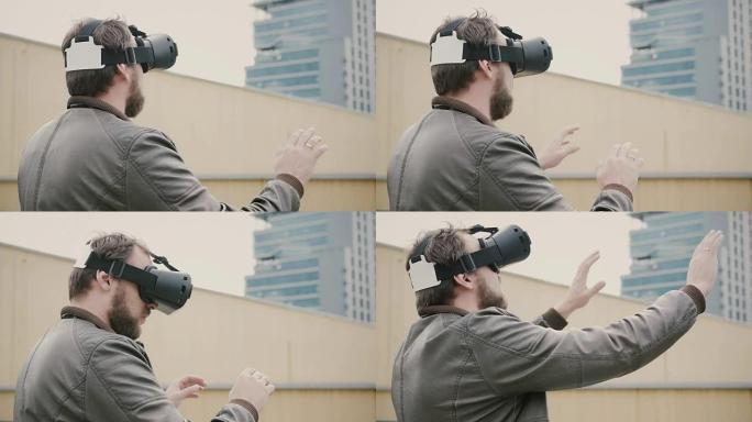大胡子的有魅力的男人在屋顶上使用虚拟现实眼镜。全高清