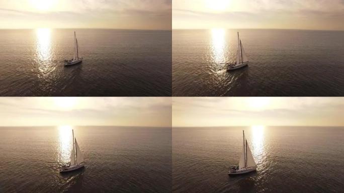 日落时分，空中无人机拍摄了一艘帆船在海中。
