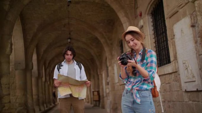 年轻的游客带着地图和相机参观中世纪老城