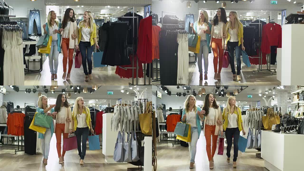 三个快乐的女孩正穿着五颜六色的衣服穿过一家服装店。