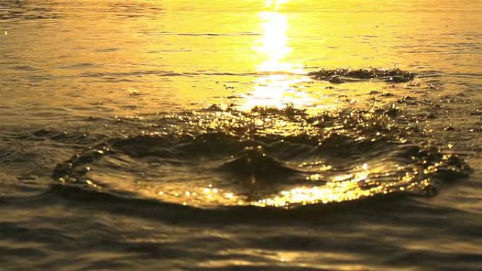 慢动作: 日落时在水中扔石头