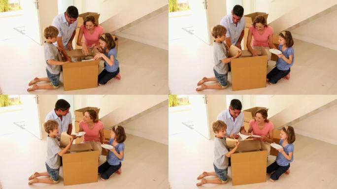 幸福家庭在他们的新家中打开盒子