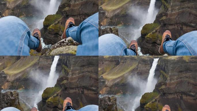 人的观点坐在悬崖上，看着峡谷中的瀑布
