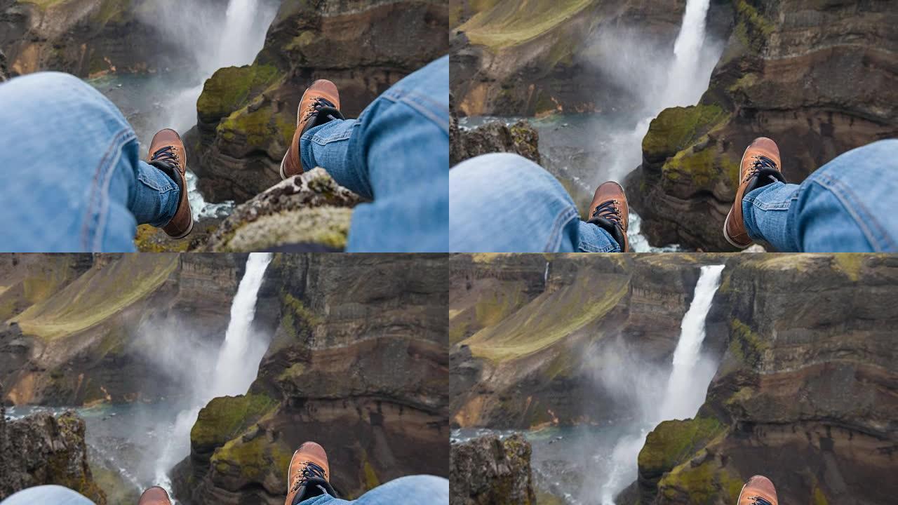 人的观点坐在悬崖上，看着峡谷中的瀑布