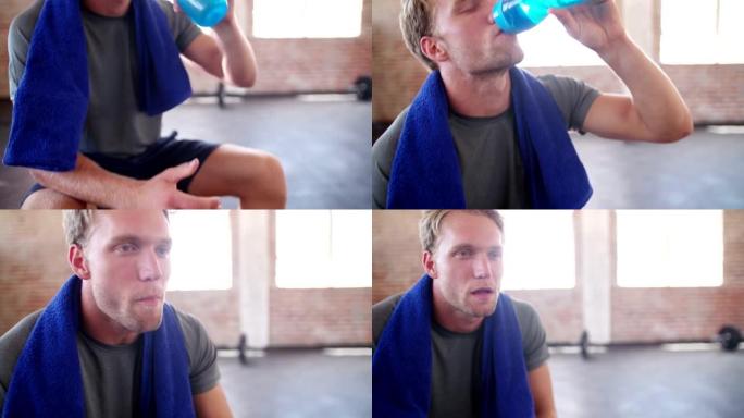 在健身房训练休息期间，专注于健身房的彩色塑料水瓶