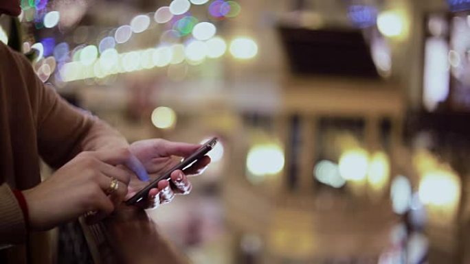 女人在购物中心使用智能手机发短信