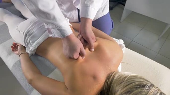 女人背部的手动按摩治疗。