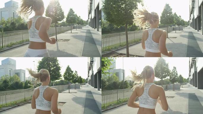 慢动作: 金发不知名的健康女人沿着阳光普照的城市大道奔跑。