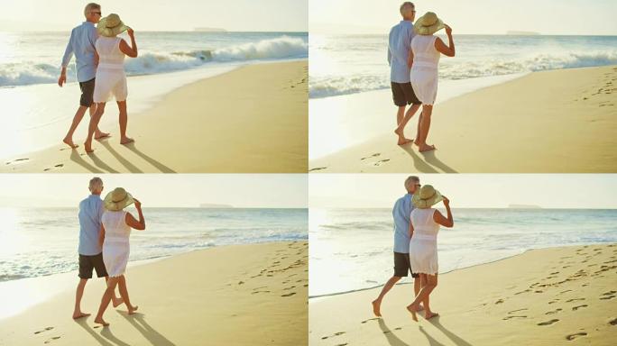 日落时在海滩上散步的快乐夫妇