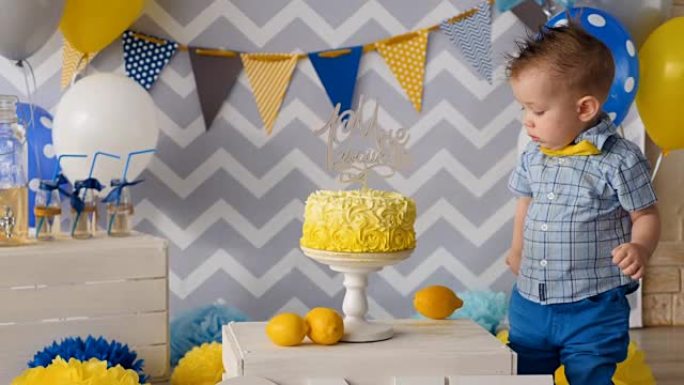 这个男孩正在用手指触摸他的生日蛋糕。