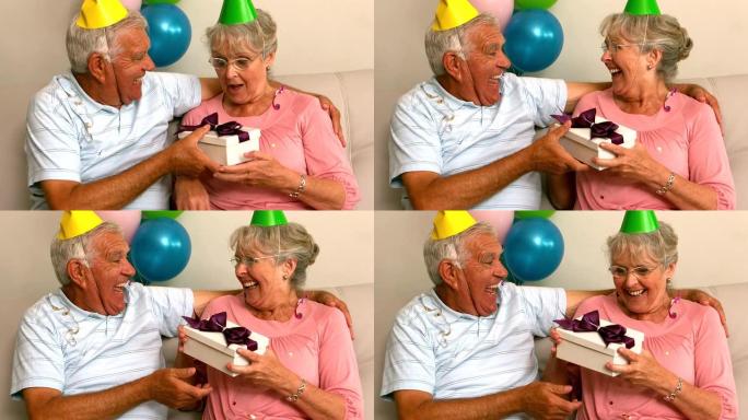 高级夫妇在沙发上庆祝生日