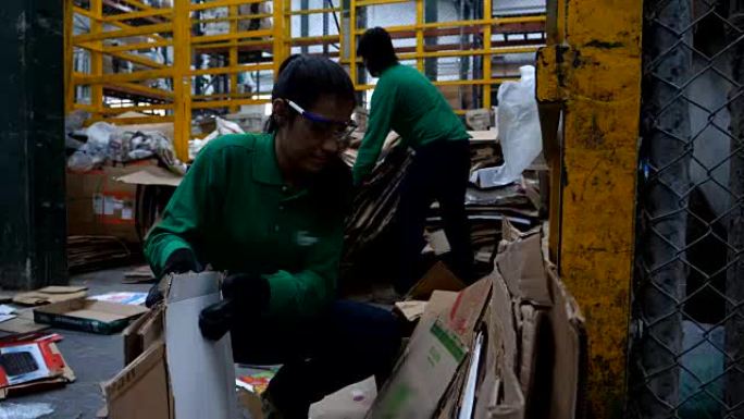 一群蓝领工人在一家回收工厂安排回收纸箱