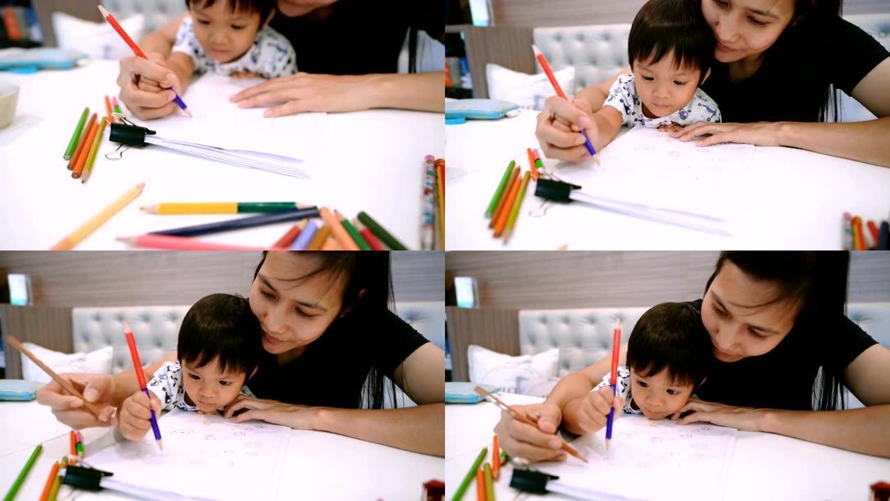 亚洲小男孩和母亲一起画画。