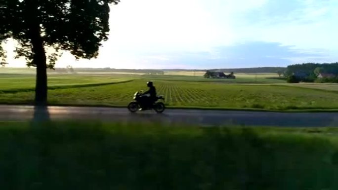 骑摩托车旅行。日落时的乡村景观