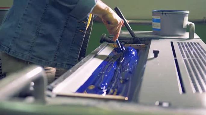 一名员工正在工业印刷机中准备蓝色油漆