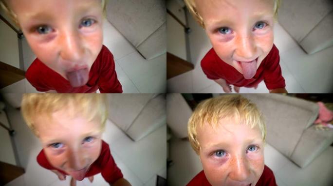 小男孩伸出舌头靠近相机