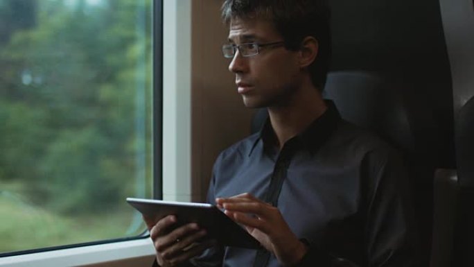在火车上旅行时使用平板电脑的人