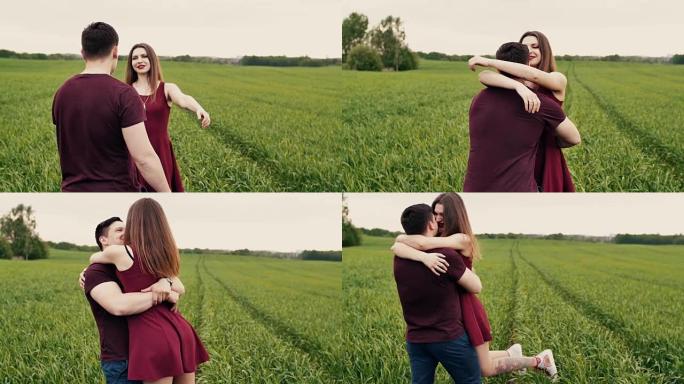 浪漫的年轻夫妇。他们拥抱并在绿色的田野中旋转。慢镜头，稳定镜头