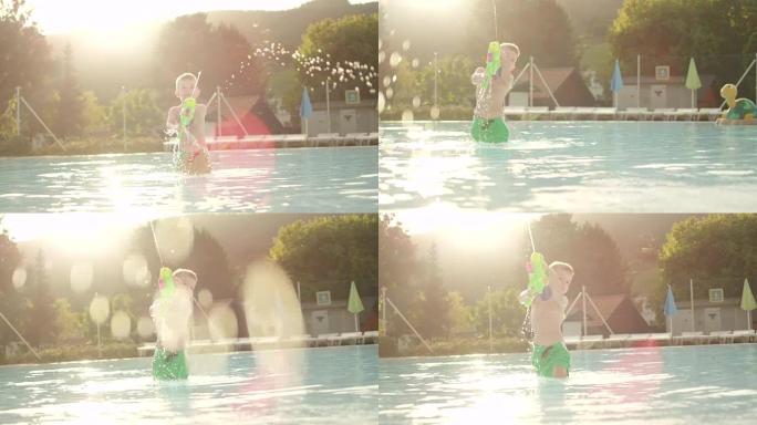 慢动作: 快乐男孩在美丽的夏日日落时阳光明媚的假期在游泳池里玩水枪