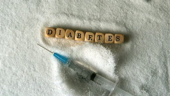 注射器落入骰子旁边的糖堆拼写糖尿病