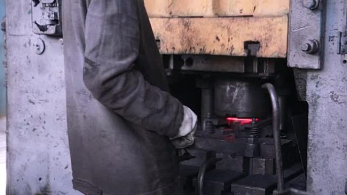 工人在金属锻造工厂使用自动金属加工机进行操作