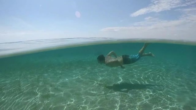 水下: 快乐的年轻人在水下游泳，探索神奇的海洋