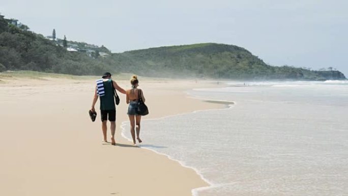 年轻夫妇在沙滩上散步