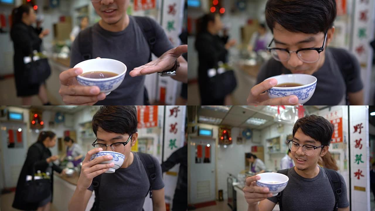 亚洲男子在镜头前展示和品尝著名的中国凉茶