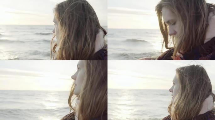 年轻迷人的女性的肖像，用格子站在海边，看着远处，思考