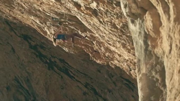 年轻的女攀岩者在比利牛斯山脉攀登一个困难的洞穴