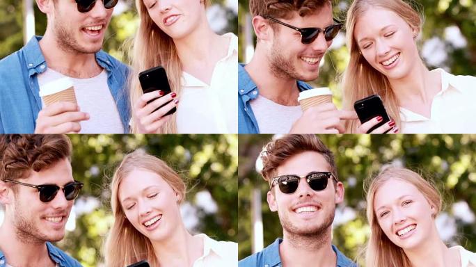 微笑的臀部夫妇使用智能手机