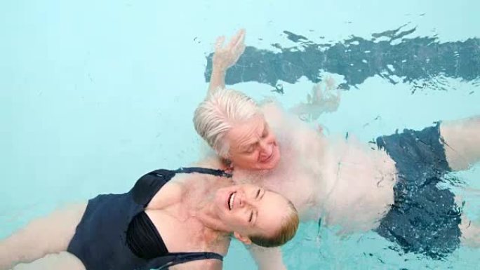 快乐的高级夫妇在游泳池游泳