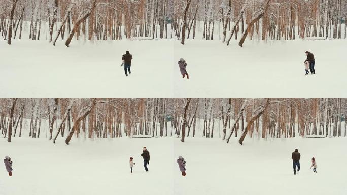 年轻的家庭在雪地里玩耍和玩耍