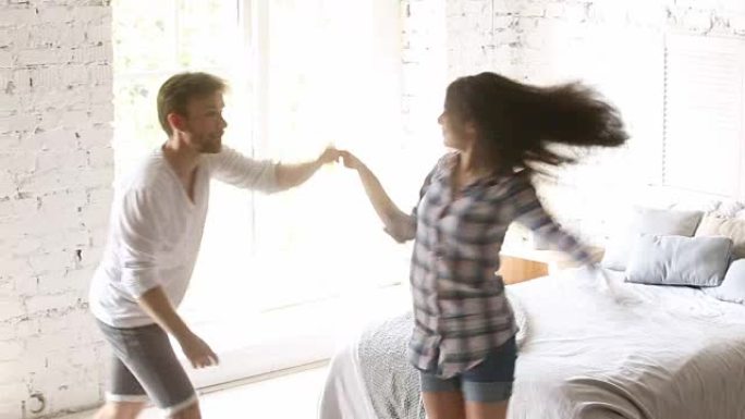 年轻夫妇在卧室跳舞，表演扭曲摇滚