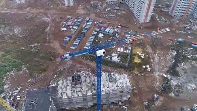 在建筑工地的蓝色塔式起重机周围旋转的摄像机。