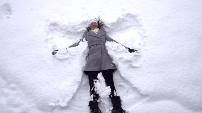 慢动作: 年轻女子制作雪天使