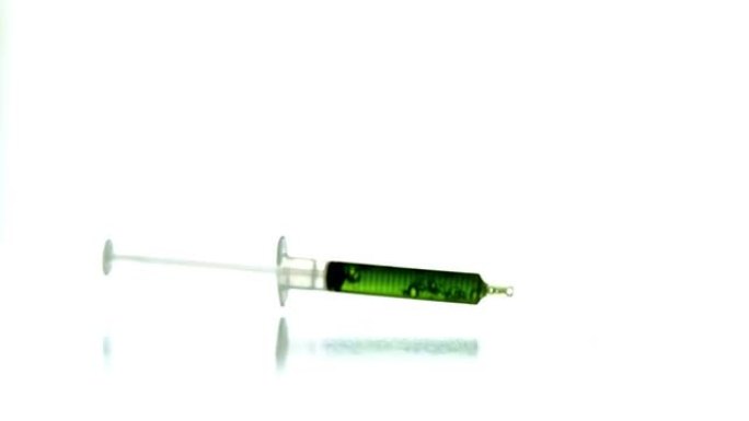 绿色液体掉落的注射器