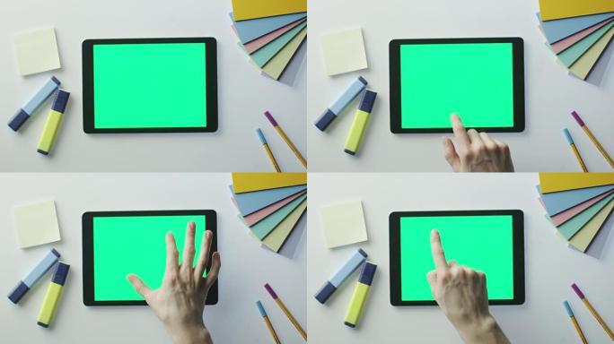在设计师的桌子上使用带有绿色屏幕的平板电脑。非常适合使用模型。在红色电影摄影机上拍摄