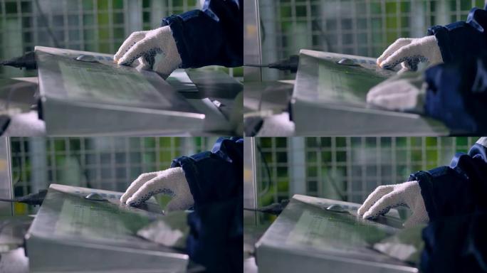 一个穿着棉手套的工人使用工业键盘。