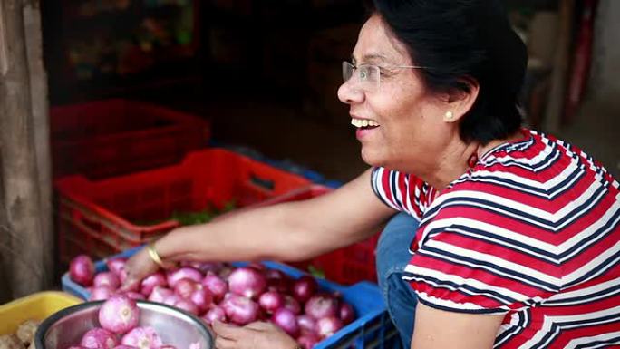 资深亚裔印度妇女在蔬菜水果店买蔬菜