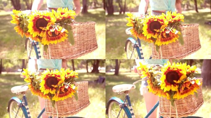 自行车篮子里的向日葵细节和公园里的女孩