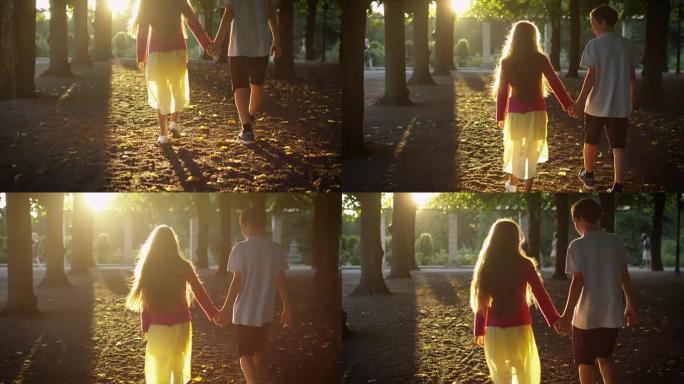 男孩和女孩手牵着手，在公园散步