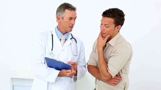 病人拿着剪贴板和他的医生说话