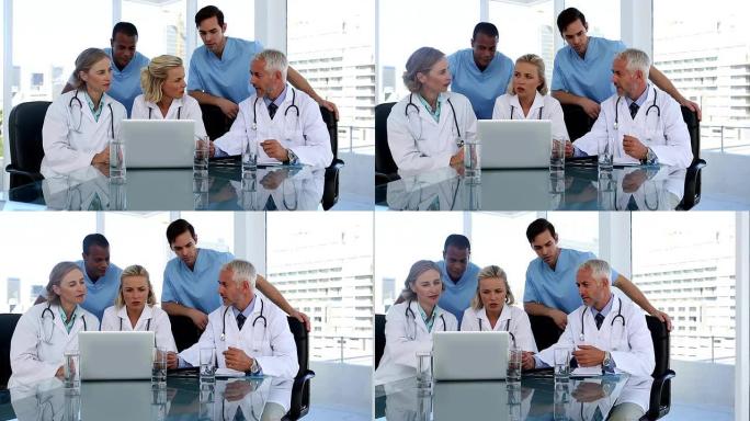 一群医生一起使用笔记本电脑