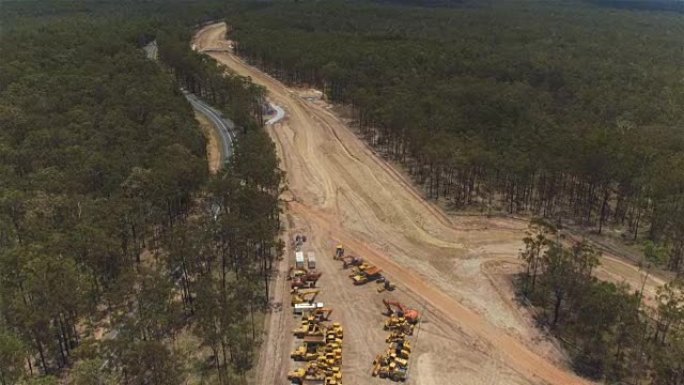 空中: 在多车道高速公路和尘土飞扬的大建筑工地上方飞行